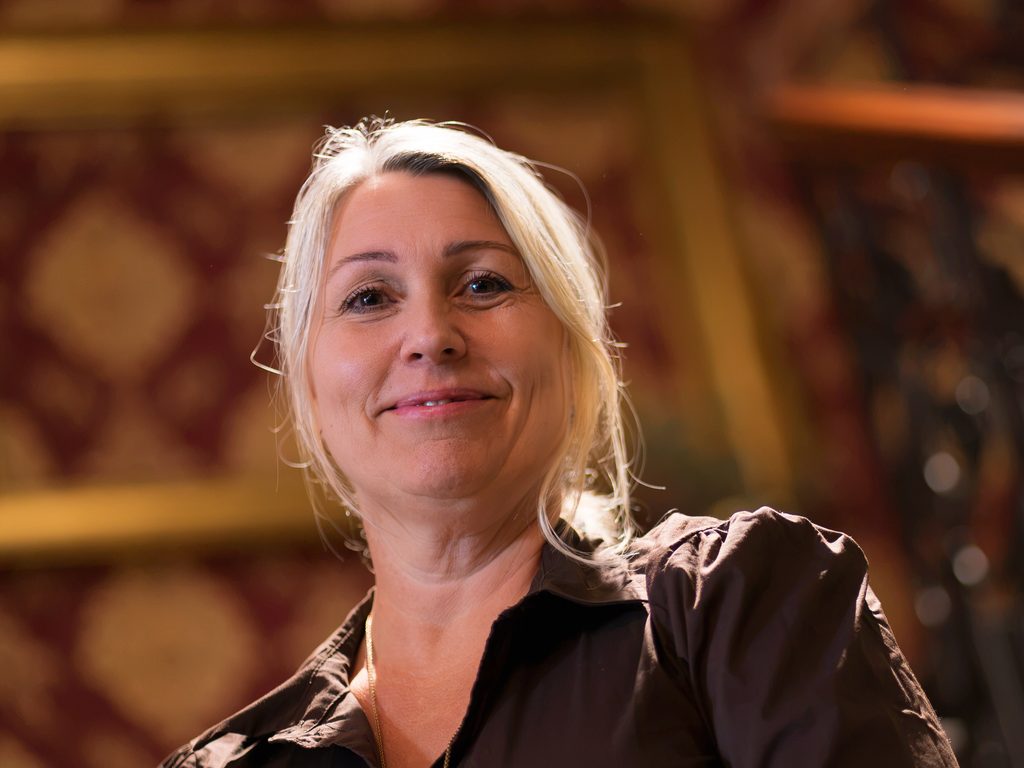 Britta Højen Holm siddende på trappen i Britta's.