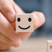 Hånd holder terning med smiley på